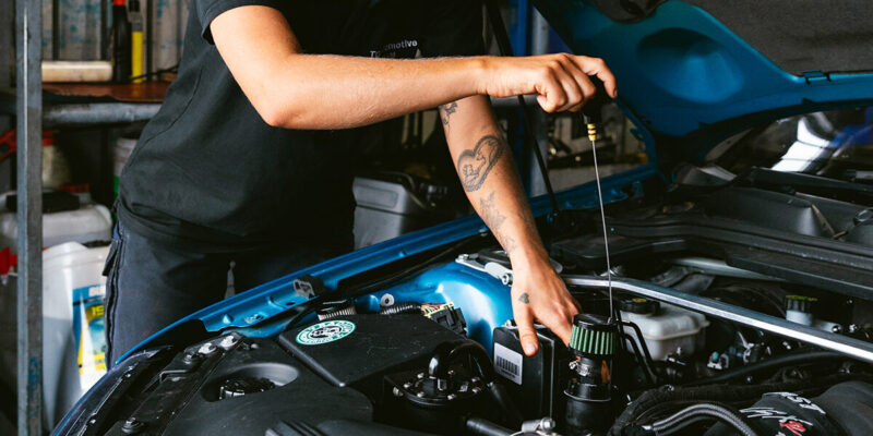 Image of mechanic in miranda checking oil during logbook servicing
